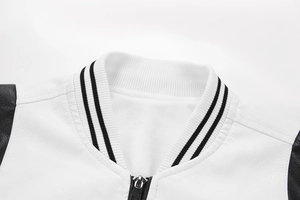 Close-up of baseball collar leather jacket with white lychee texture and black rib knit detail