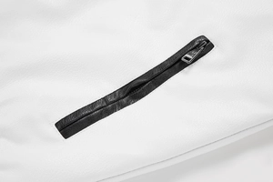 Close-up of white PU leather jacket with black zipper piping and silver metal hardware