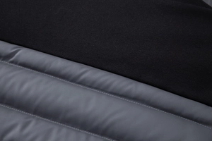 Detailed macro shot of the quilted stitching and dual-material fabric on the men jacket