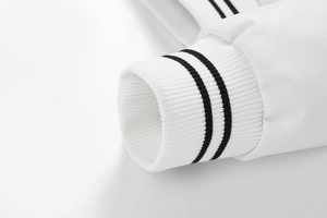 Detail of white PU leather jacket cuff featuring black striped ribbed knit texture