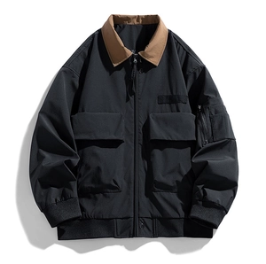 Detail of black bomber jacket featuring brown contrast collar and signature utility pockets