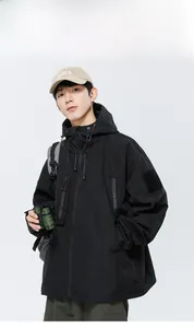Détails d'une veste tactique noire imperméable avec capuche et poches zippées