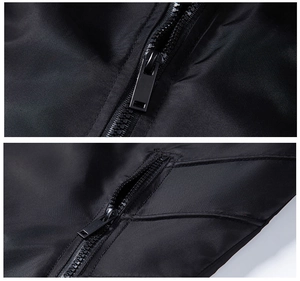 Detail view of smooth black fabric and premium metal zippers on a slim-fit jacket
