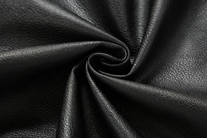 Detailed close-up of premium black PU leather fabric showing fine litchi grain texture