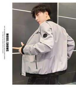 Detail view of light grey bomber jacket with ribbed cuffs and black sleeve emblem