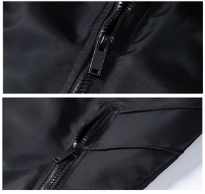Close-up of black windproof jacket featuring metal zippers and a side zipper pocket