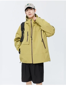 Détail de la veste technique imperméable vert moutarde avec poches et poignets velcro