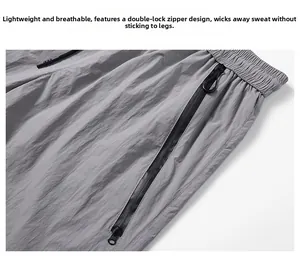 Detail of grey outdoor pants featuring elastic waistband with drawstring and zipper pocket
