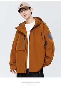 Détail de la veste outdoor caramel montrant les poches tactiques et le patch velcro