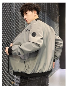 Detail of grey baseball jacket with black cursive back embroidery and arm badge