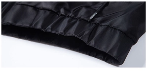 Detail shot of black biker jacket hem featuring elastic ribbing and Fashion woven label
