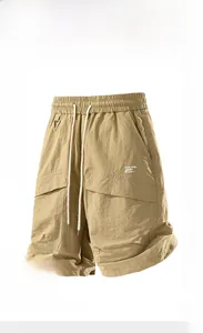 Detail of khaki outdoor shorts showing water-repellent fabric and embroidered side pockets