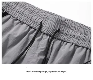 Detailed macro view of the elastic waistband and black drawstring on light gray sun protection pants