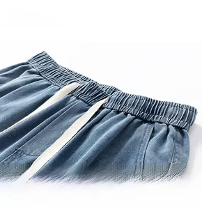 Close-up of washed denim shorts featuring elastic waistband and cotton drawstring