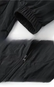 Détails des poignets élastiques et du zip sur la veste de protection solaire noire