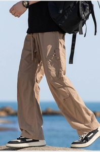 Detail of khaki outdoor cargo pants with elastic drawstring waist and side flap pockets
