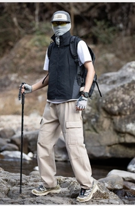 Detail of outdoor multi-pocket functional vest and cargo pants for camping and hiking
