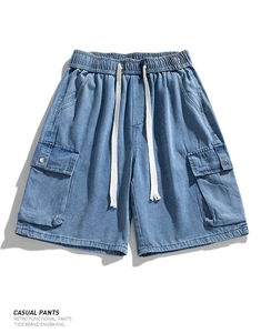 Detail view of denim cargo shorts with elastic drawstring waist and flap pockets