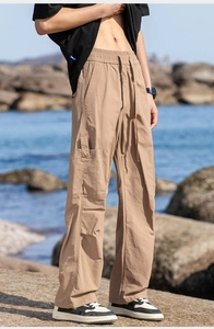 Detail of khaki outdoor cargo pants featuring elastic drawstring waist and side flap pockets
