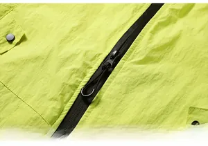 Close-up of fluorescent green sun protection jacket featuring a black zipper and fine texture