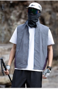 Detail of outdoor vest featuring windproof gray fabric and purple side stitching textures