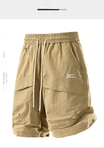Detail of khaki cargo shorts showing elastic waist with white drawstring and pocket hooks