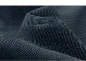 Detailed macro shot of dark washed cotton denim fabric with visible twill texture on cargo shorts