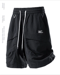 Detail of waterproof nylon cargo shorts with elastic waist and white drawstrings
