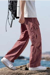 Detail of outdoor cargo pants in soft mauve featuring side pockets and textured fabric