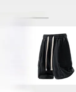 Detail of black cargo denim shorts featuring large utility pockets and elastic drawstring