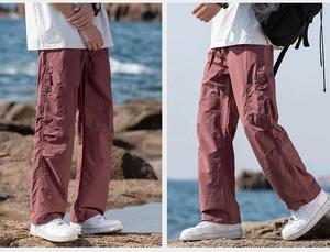 Macro view of water-resistant cargo pants with large side pockets in brick red color