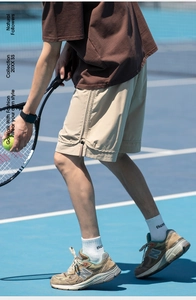 Dettaglio dei pantaloncini sportivi beige ad asciugatura rapida con tasca laterale zip