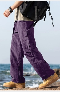 Detail of purple waterproof cargo pants with large side pockets and relaxed straight fit
