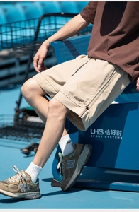 Dettaglio dei pantaloncini sportivi kaki con tasca laterale a zip e coulisse in vita