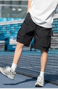 Detail of black cargo shorts featuring tactical large side pockets and woven fabric texture