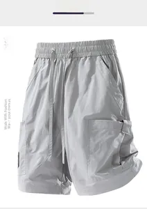 Detail of grey cargo shorts showing elastic waistband, drawstrings, and side pockets