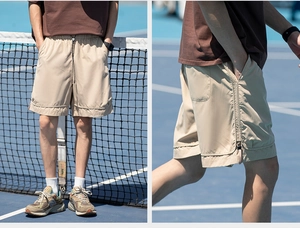 Dettaglio pantaloncini sportivi kaki con vita elastica e coulisse su campo blu