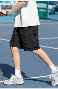 Detail of black techwear cargo shorts featuring waterproof nylon fabric and 3D utility pockets