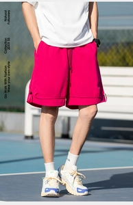 Dettaglio dei pantaloncini sportivi magenta con orlo a doppio strato e coulisse su campo da tennis