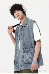 Détail du gilet en jean bleu clair avec poches utilitaires et boutons en métal