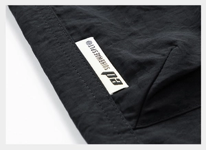 Close-up of durable black water-repellent fabric with reinforced stitching and woven label