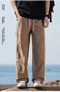 Primo piano dei pantaloni casual marroni con strisce laterali e coulisse in vita