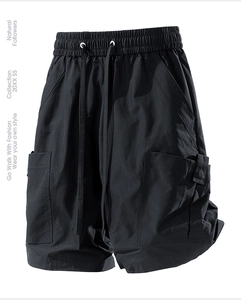 Detail view of black cargo shorts with elastic drawstring waist and side utility pockets