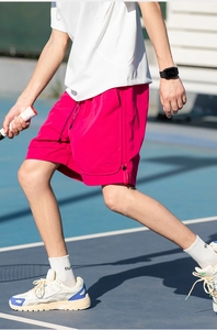 Dettaglio dei pantaloncini sportivi rosa ad asciugatura rapida con tasche zip e spacchi