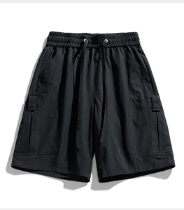 Detailed view of black cargo shorts featuring elastic waistband with drawstring and large pockets