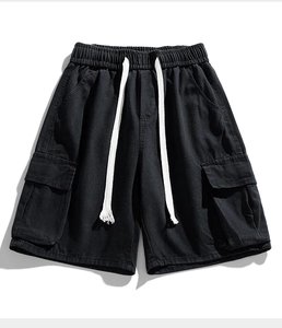 Flat lay of black cargo denim shorts with drawstring waist and large utility pockets
