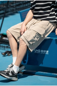 Detail view of khaki cargo shorts with side flap pockets and durable outdoor fabric