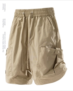 Detail of khaki cargo shorts showing elastic drawstring waist and tactical side pockets