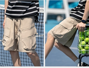 Detail of khaki cargo shorts with functional pockets and drawstring on tennis court