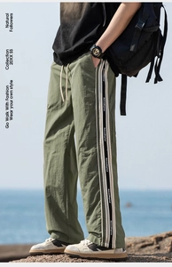 Scatto all'aperto di pantaloni cargo verde militare con strisce laterali e stampe